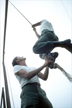 US Army recruit climbs a rope on the obstacle course.