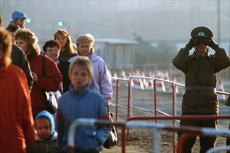 East German policeman monitors activities with binoculars