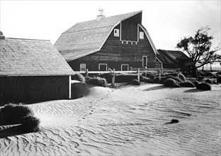 Barn on a farm with sand drifts during the 1930s