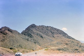 Car driving down a rural road in Nevada ca. 1966