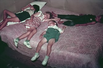 Children asleep on bed during square dance