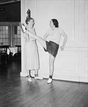 Dancer in a dance studio stretching her leg