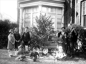 Early 1900s family in front of their outdoor Christmas tree ca. 1921