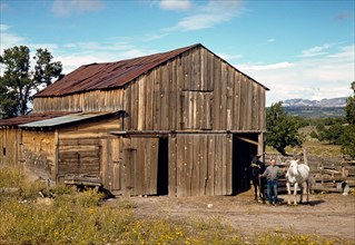 Homesteader in front of his barn