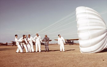 Instructor explaining the operation of a parachute to student pilots