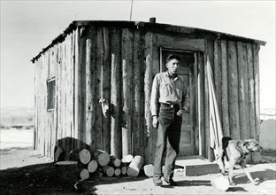 Man and Dog in Front of Cabin