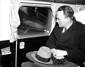Man seated in an airplane looking out a window