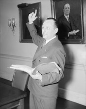Man speaking while holding a book