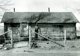 Man Standing in Front of Cabin ca 1948