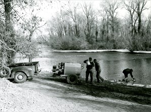 Men at River Gathering Water onto Truck