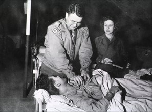 Military doctor and nurse tend to wounded soldier ca. 1945