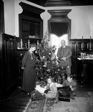 Parents with children around a Christmas tree