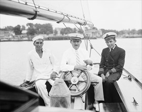 Three men on a deck of a sailboat