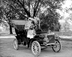Woman driving an early 1900s automobile