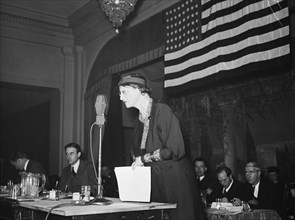 Woman speaking into a microphone at a patriotic event