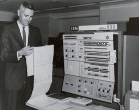 Worker reading printout sheet July 1967 in front of IBM 360