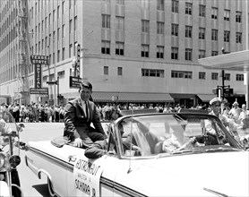 (1962) Astronaut Walter Schirra riding in back of a car during a welcome parade in Houston, Texas.