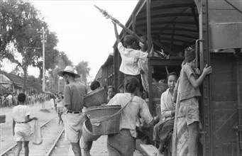 Indonesian travelers board a train at Madioen in Indonesia, Dutch East Indies ca. 1949