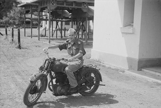 1947 - Motorcyclist; Man riding a motorcycle in Indonesia, Medan, Dutch East Indies, Sumatra