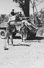 Soldier with a metal detector in search of land mines. Behind him a Humber armored car; Date June 1947; Location Indonesia, Dutch East Indies