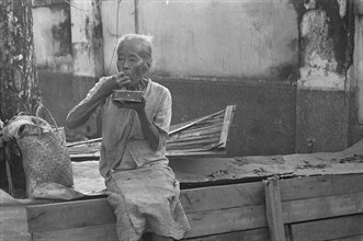 Old woman eating in Indonesia, Dutch East Indies, Palembang, Sumatra ca. 1947