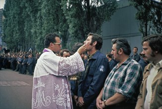 Poland History - Priest Henryk Jankowski hands out host to workers from Lenin yard during open air church service in Gdansk Poland ca. August 20, 1980