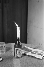 Beer bottle with candle. In addition, a newspaper ca. 1947