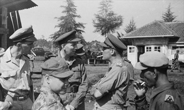 General Doorman with cigarette in conversation with officers; Date September 1946; Location Indonesia, Dutch East Indies