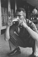 Man drinks a glass of beer and holds a beer bottle in his other hand; Date June 1947; Location Batavia, Indonesia, Jakarta, Dutch East Indies