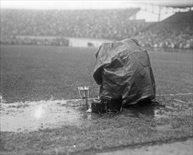 September 21, 1947 - Reporters covering a soccer match in Amsterdam take cover from the rain
