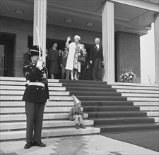 Queen Juliana leaves the town hall. A boy with a party hat sits on the stairs in Vlissingen, Zeeland ca. May 1965