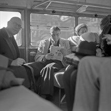 Boxer Willy Quentenmeyer reading a newspaper while sitting on a bus ca. 1947