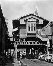 1930s New York City - El' station, Ninth Avenue Line, Christopher and Greenwich Streets, Manhattan. Line of cabs, below elevated railroad station, elevated structure (West Side Highway?) beyond. ca. 1...