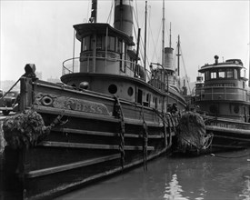 Looking along beam of tugboat Bess and at bow of McAllister Bros. tugboat, other boats in background ca. 1936
