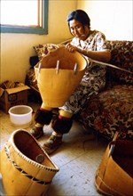 Ca. Early 1970s - Eskimo woman making berry basket of birch bark, Ambler Alaska