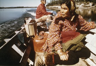 Eskimo man and woman boating along Kobuk River near the village of Ambler ca. 1973-1975