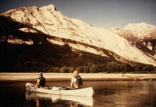 7/17/1974 - Men paddling a canoe on the John River, Alaska