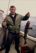 5/16/1973 - fisherman holding his caught Cod, Kenai Fjords, Alaska