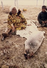6/18/1973 - Eskimo woman with young harbor seal, to be used for food, and its skin for a container, or 'poke' for seal oil