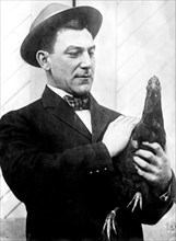 Nap Lajoie between seasons (man holding hen) ca 1909