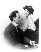Ossip Gabrilowitsch, 1878-1936, half-length portrait, seated at piano, right profile, with wife Clara Clemens