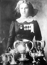 Alsie Aykroyd in front of her trophies 7 13 1910