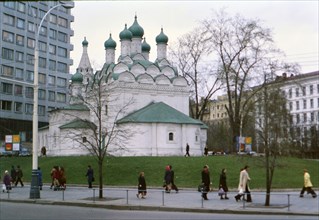 Buildings and architecture in a major city in Russia, pedestrians walking by what looks to be an Orthodox church late 1970s ca. 1978