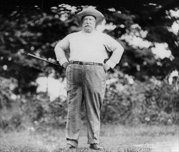 William Howard Taft, 1857-1930, full, standing with arms on hips, holding golf club, facing front 1909