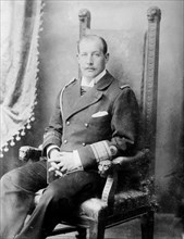 Prince George of Greece, seated, in uniform