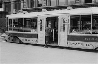 Man entering a one step trolley car in New York City ca. 1910-1915