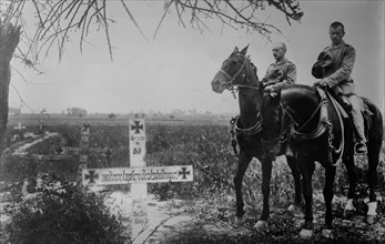 German soldiers on horseback mourning at graves of soldiers on the battlefield during World War I ca. 1914-1915