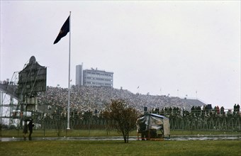 View of crowd in stands and parked cars at Beaver Stadium for Penn State football game (December 1962)