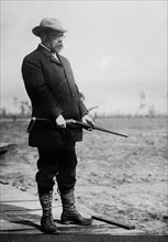 Composer and conductor John Philip Sousa, holding a gun ca. 1910-1915