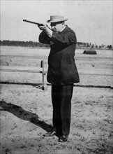 Composer and conductor John Philip Sousa, shooting a gun ca. 1910-1915